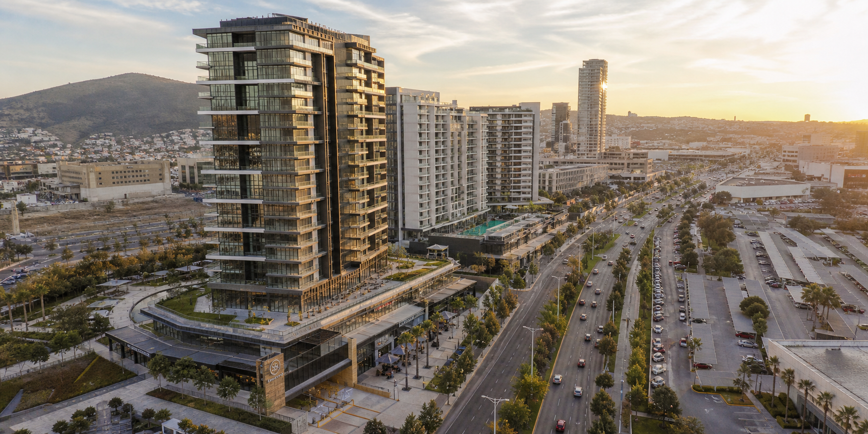 Vista aérea de desarrollo residencial de lujo en una zona urbana en crecimiento. Se observan edificios residenciales de alta gama, nuevas vialidades y plazas comerciales.