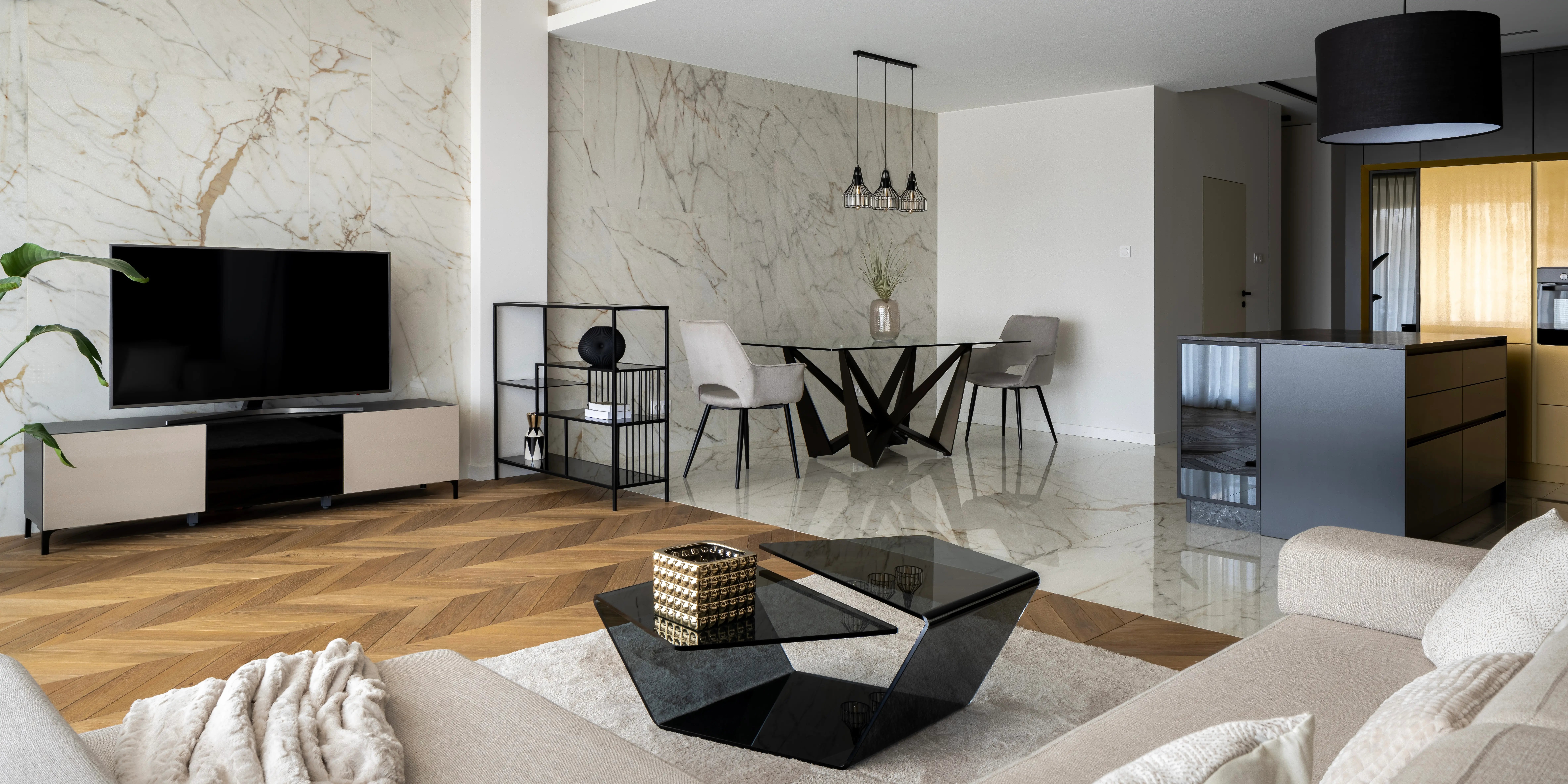 Deprtamento de lujo en Bosque Real con sala de estar con paredes de mármol, abierta al comedor con mesa moderna y elegante cocina en negro y oro