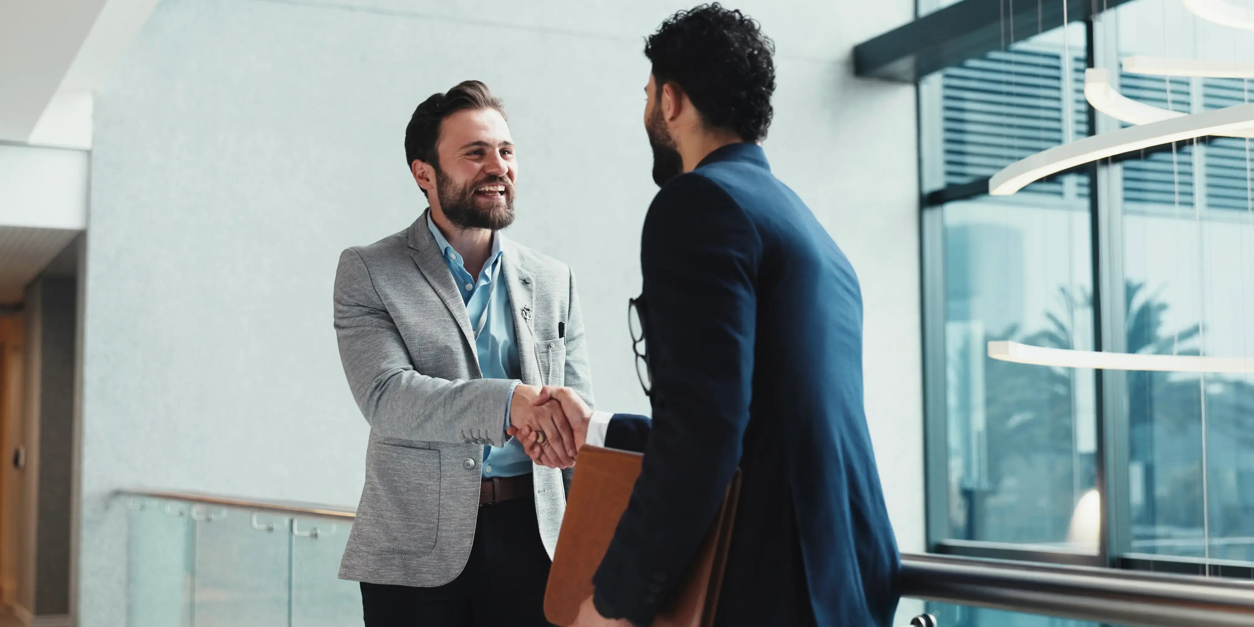 Exisotos empresarios de una comunidad exclusiva de networking dándose apretón de mano