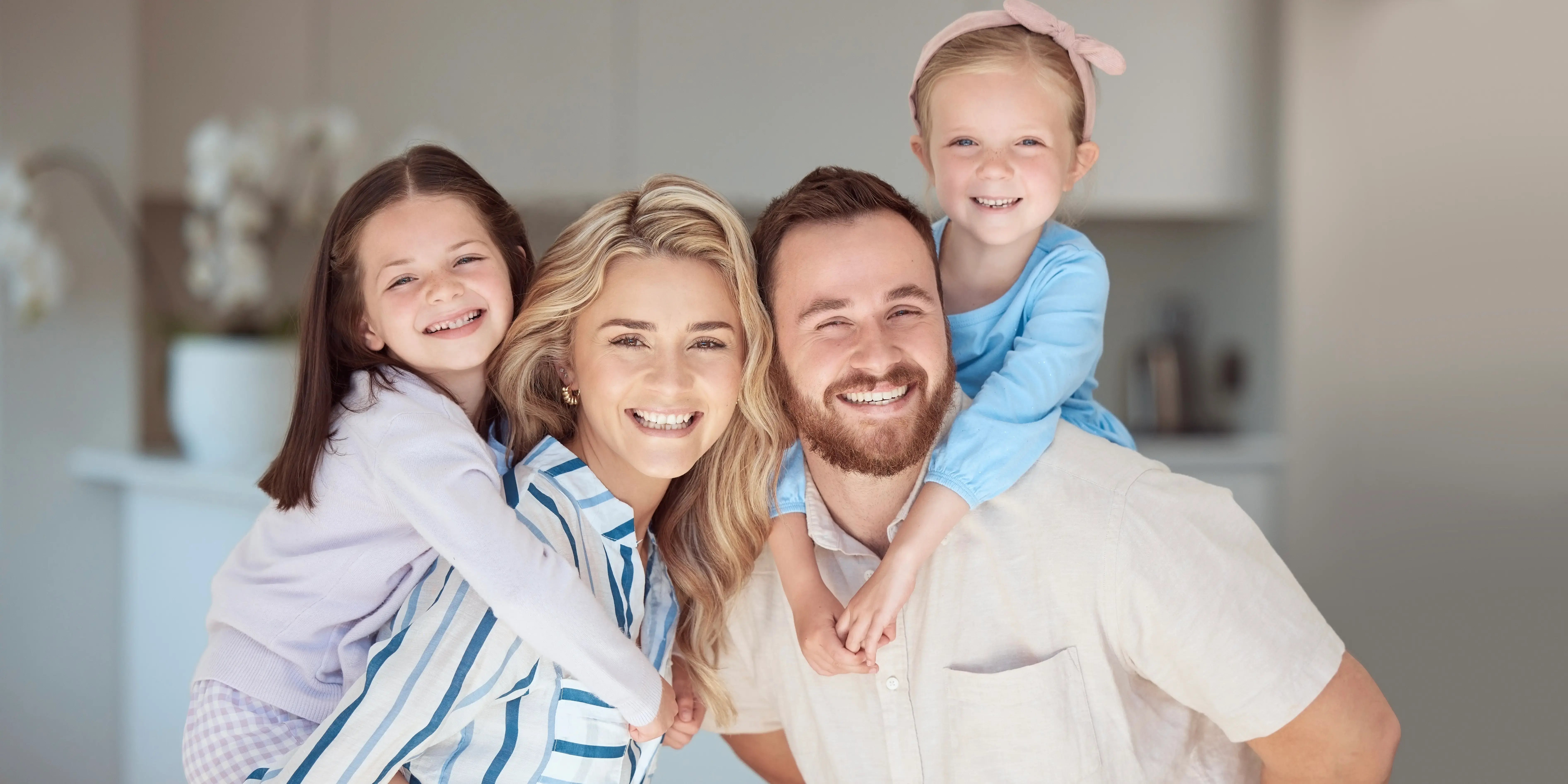 Familia con hijas en la sala de su nuevo departamento de un desarrollo inmobiliario formando su patrimonio familiar
