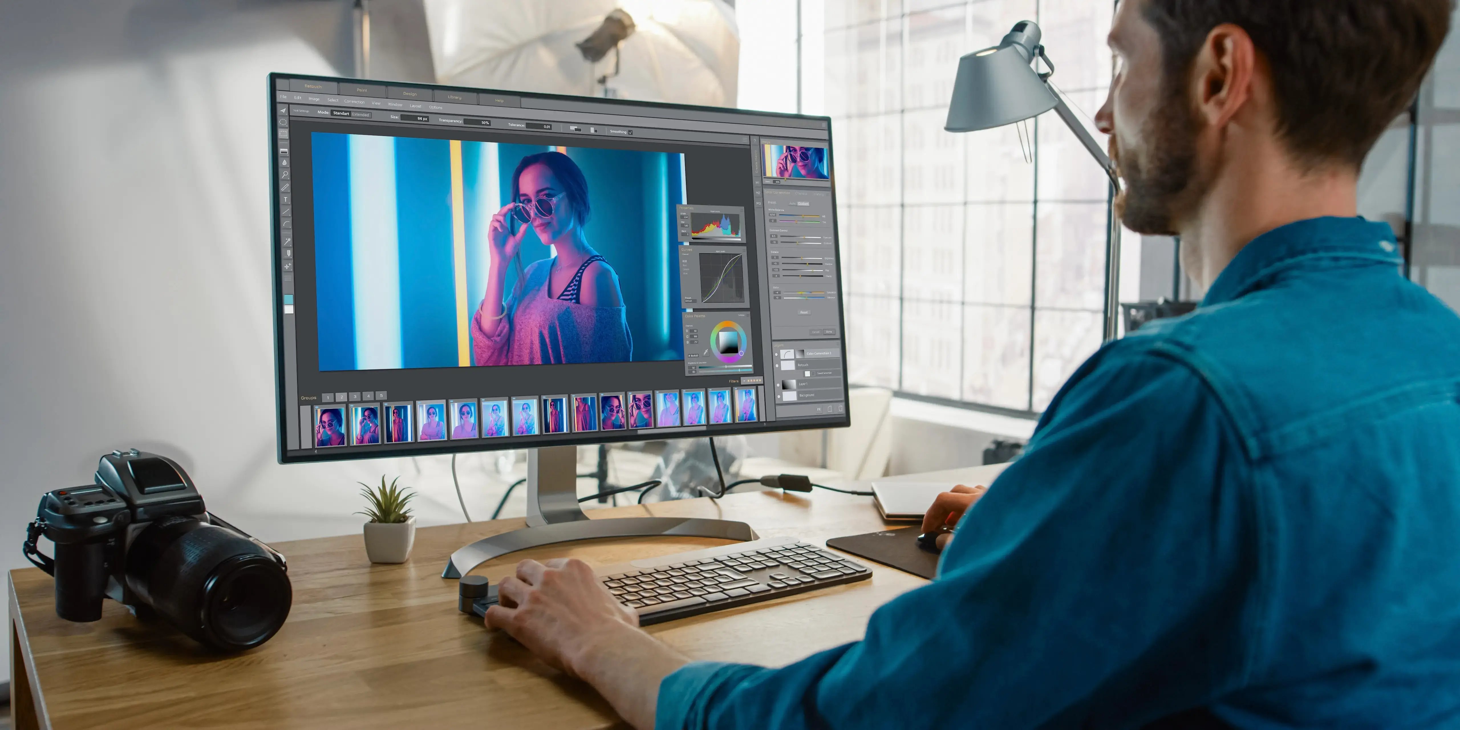 Hombre editando unas fotografías en su computadora como negocio rentable con poca inversión