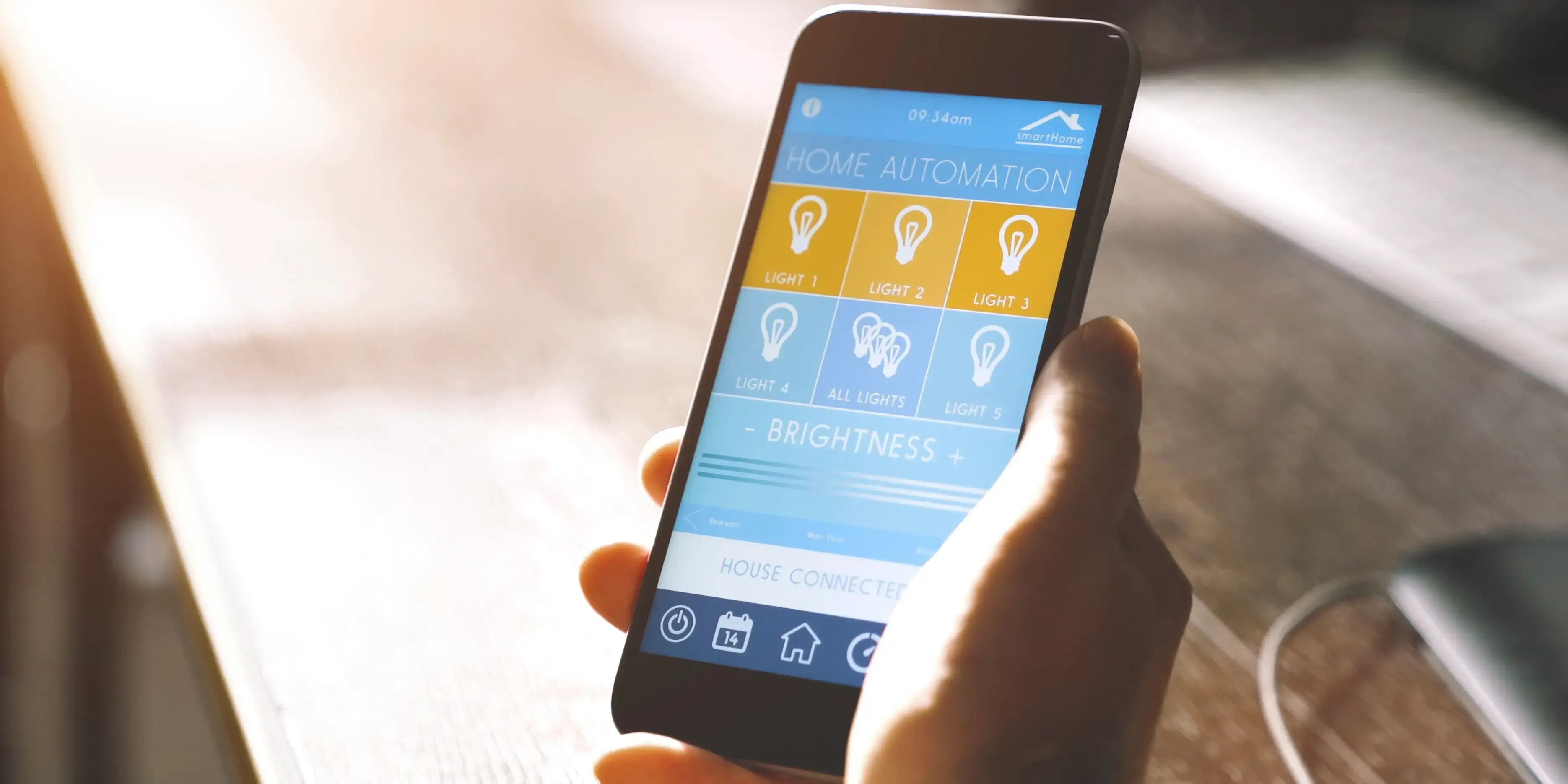 Hombre sosteniendo smartphone y configurando app para automatizar la casa y apagar las luces al salir