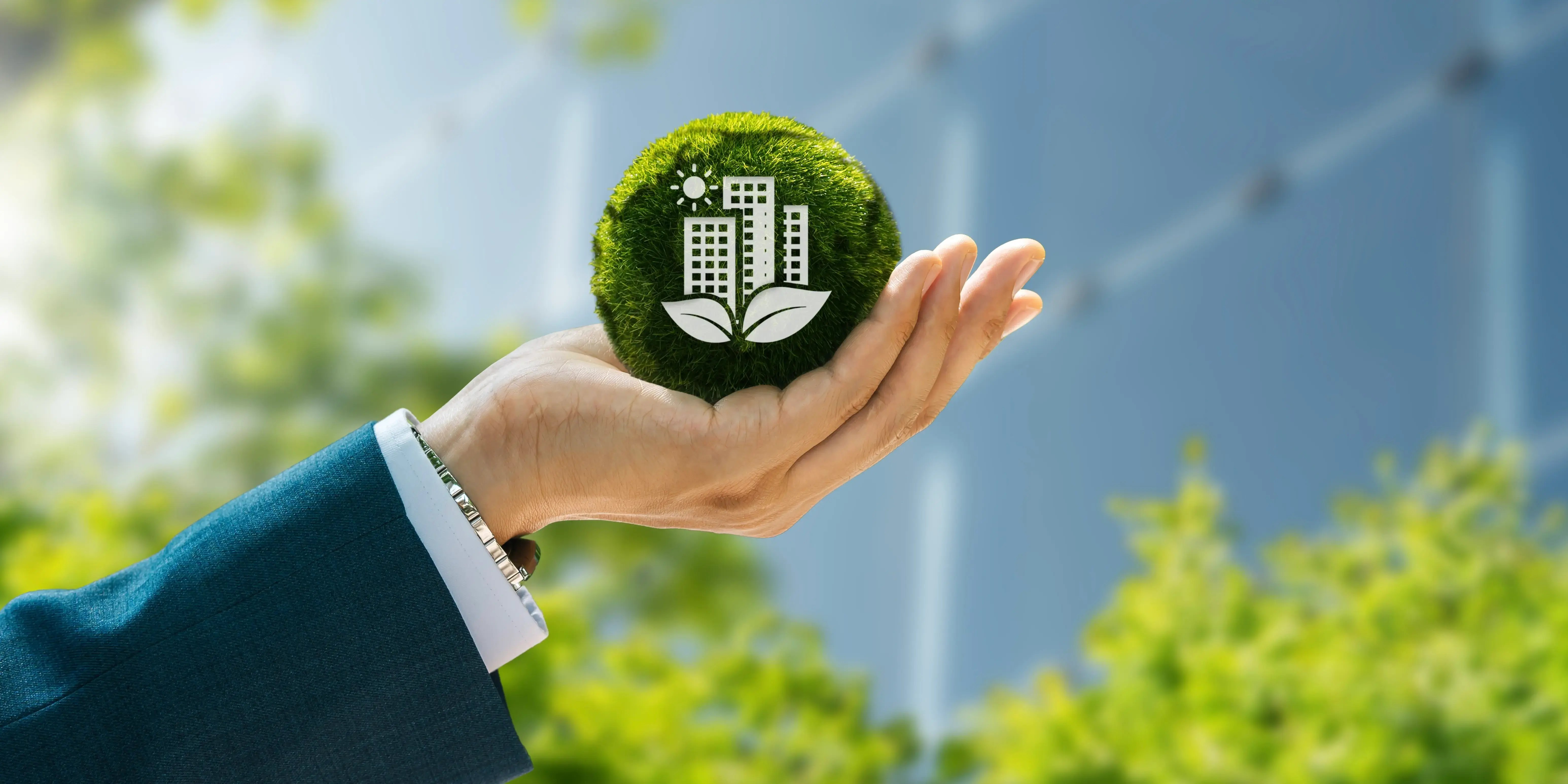 Hombre sosteniendo una bola verde y dentro la silueta de un edificio de arquitectura sustentable