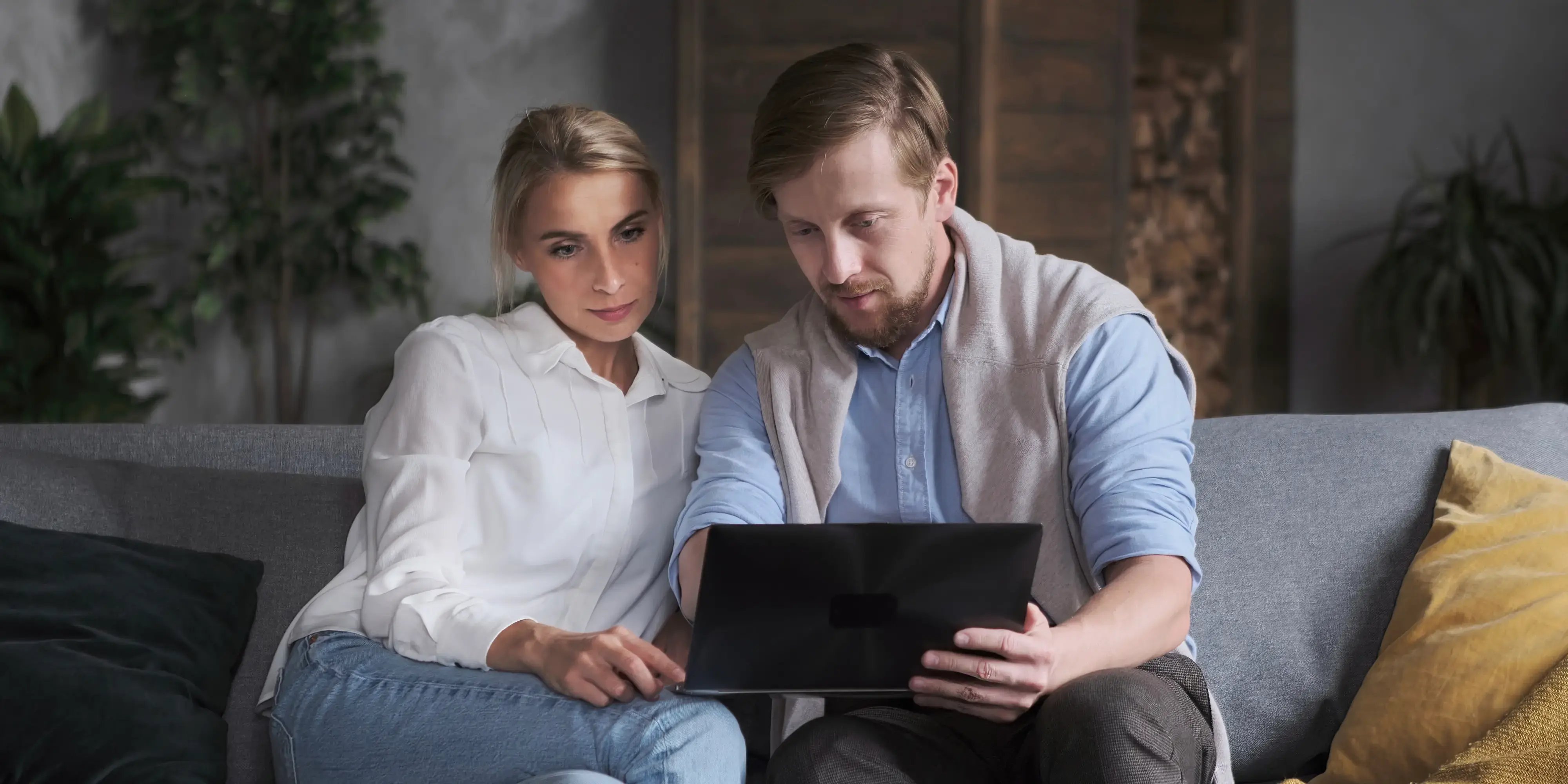 Hombre y mujer navegando en un ipad por la web buscando ideas para decorar su departamento en Bosque Real
