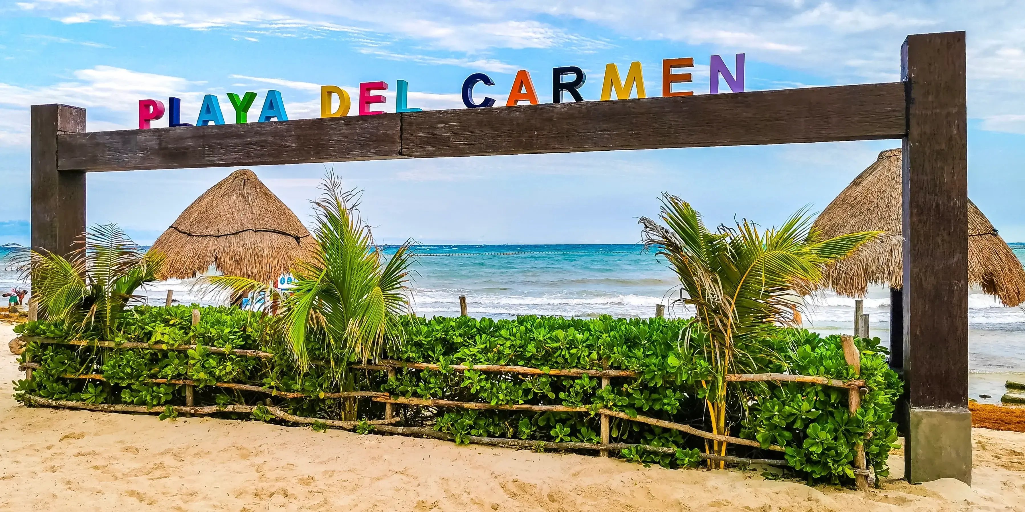 Letrero colorido de playa del carmen con el már al fondo, playa de México