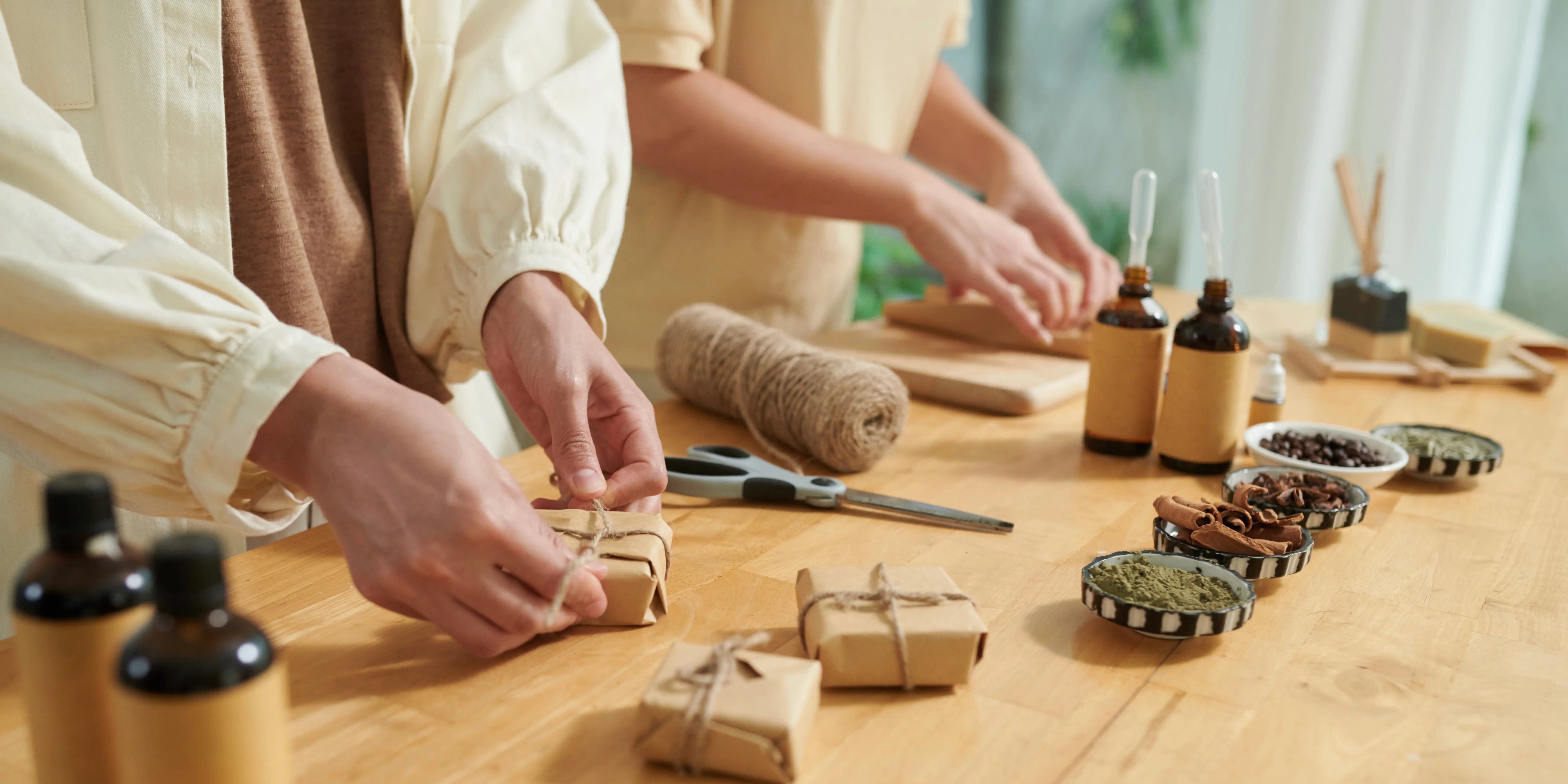 Manos de mujer atando nudo en la barra de jabón hecha a mano en papel artesanal como negocio rentable con poca inversión