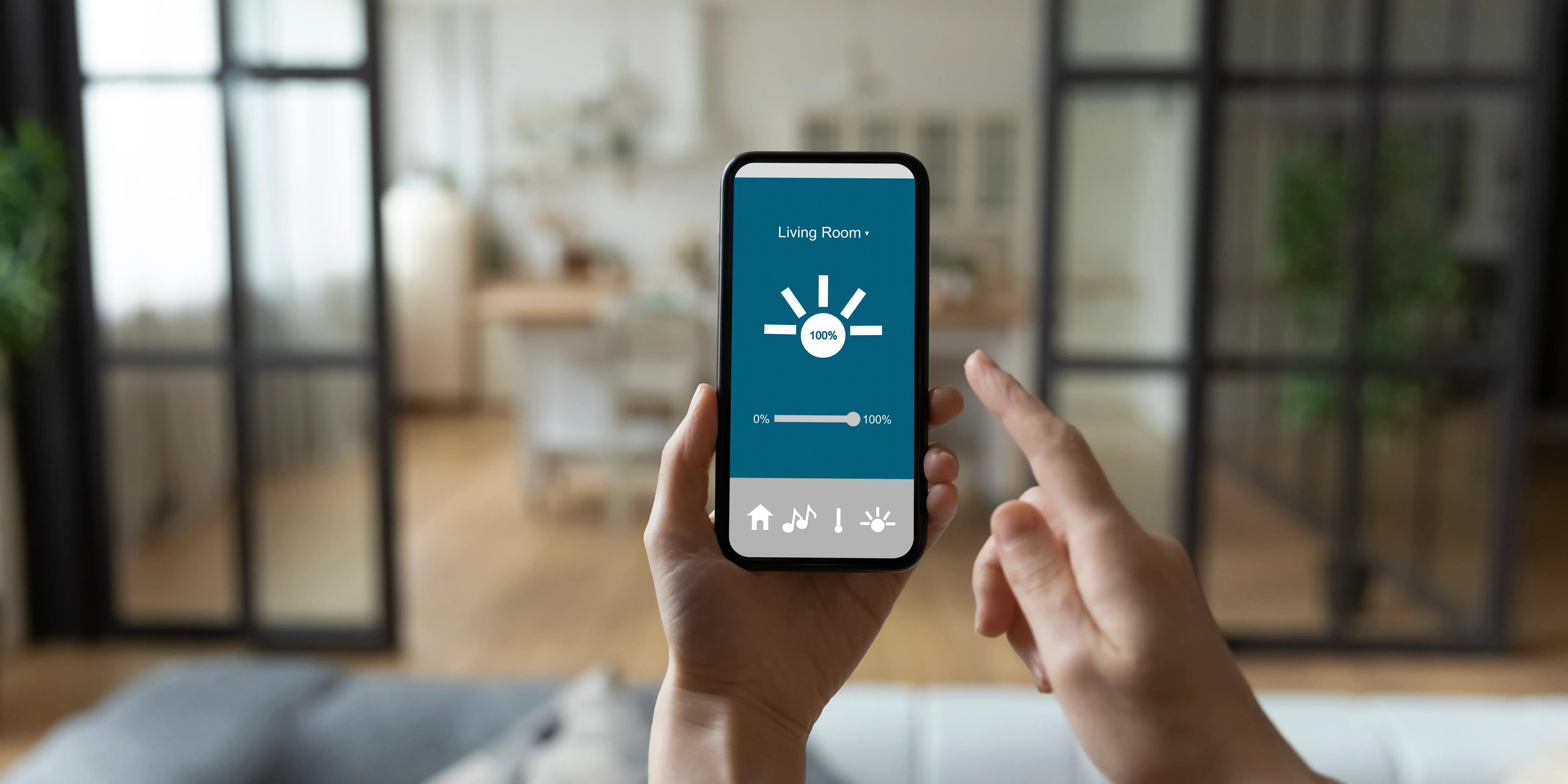 Mujer que controla objetos electrónicos en su departamento en Bosque Real a través de una interfaz inteligente de un smartphone