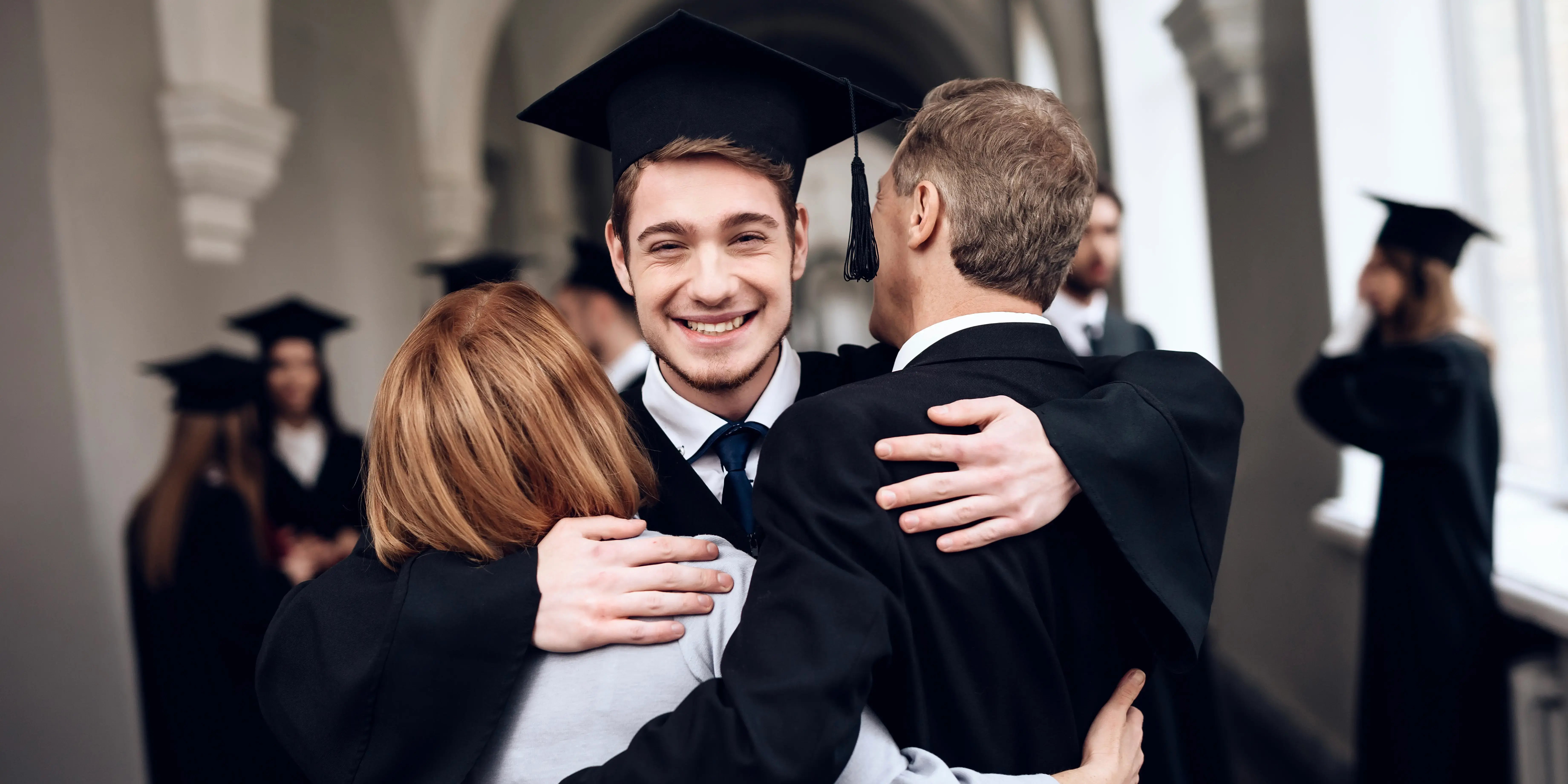 Padres felicitan a estudiante que termina sus estudios en la universidad cerca de Bosque Real