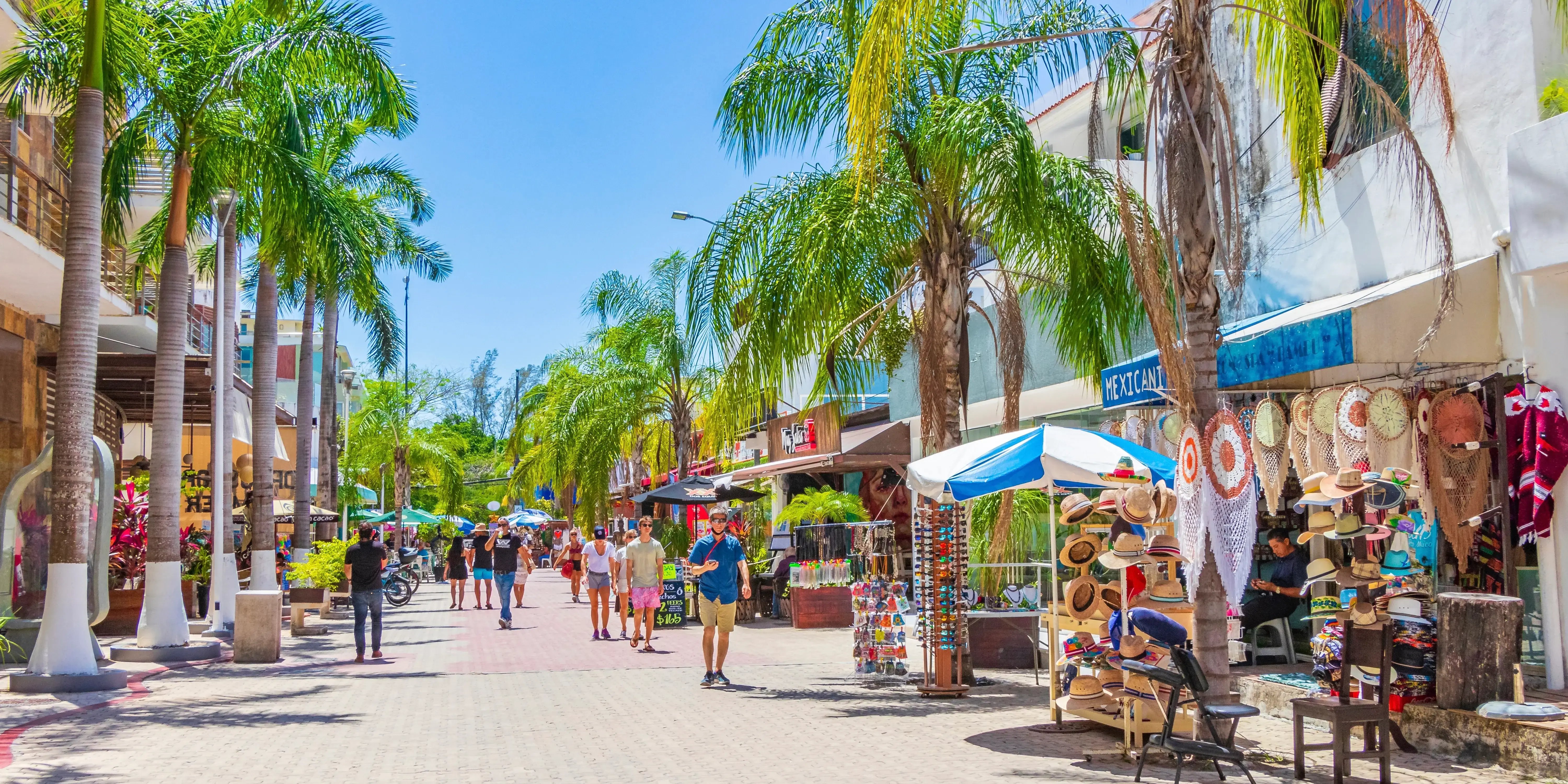 Paisaje urbano de La Quinta Avenida con restaurantes tiendas de souvenirs y edificios de Playa del Carmen