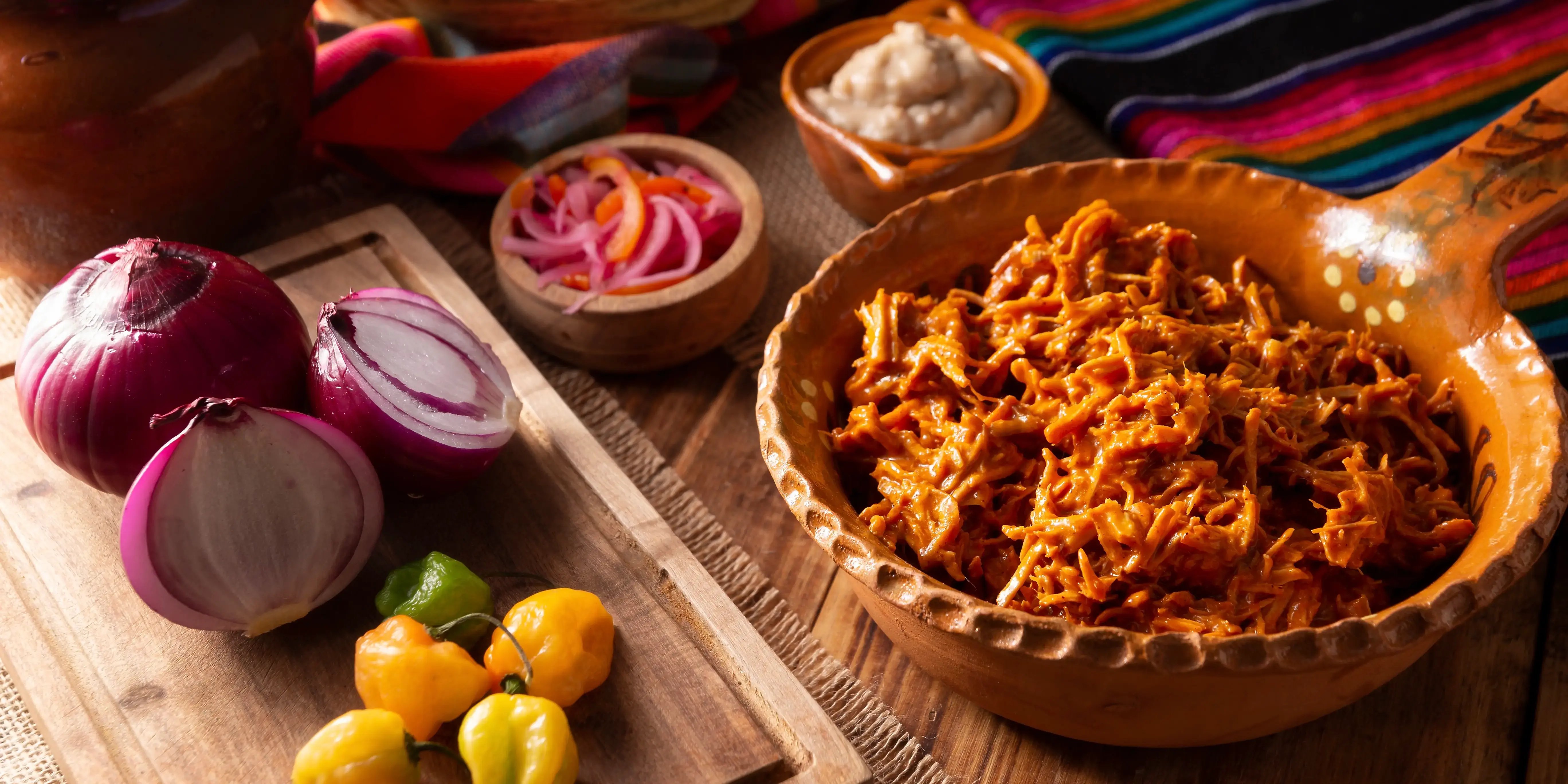 Platillo de cochinita pibil acompañada de cebolla morada y chile abanero