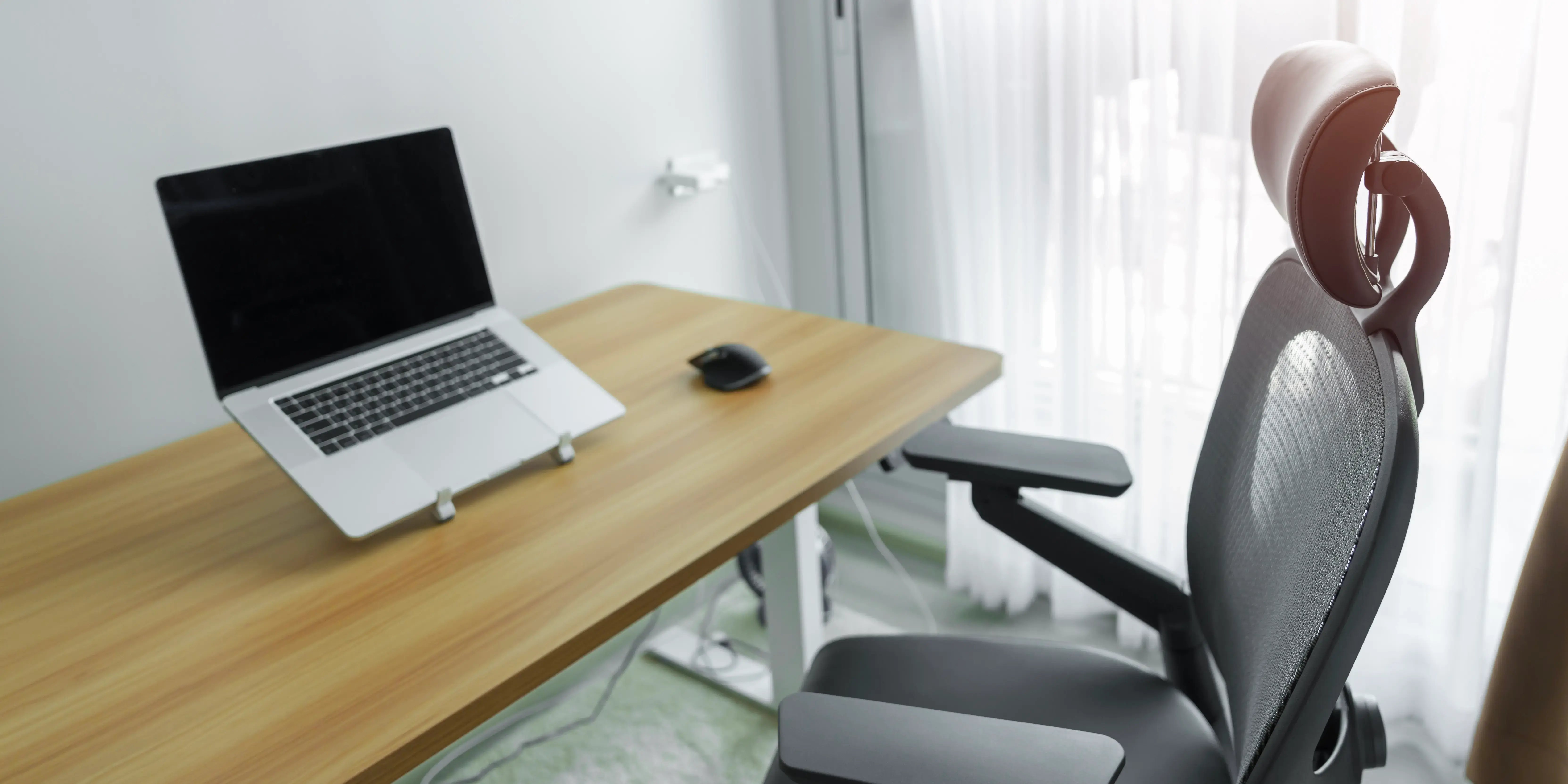 Silla ergonómica y mesa ajustable con ordenador portátil para crear un entorno favorable a la salud y hacer home office y