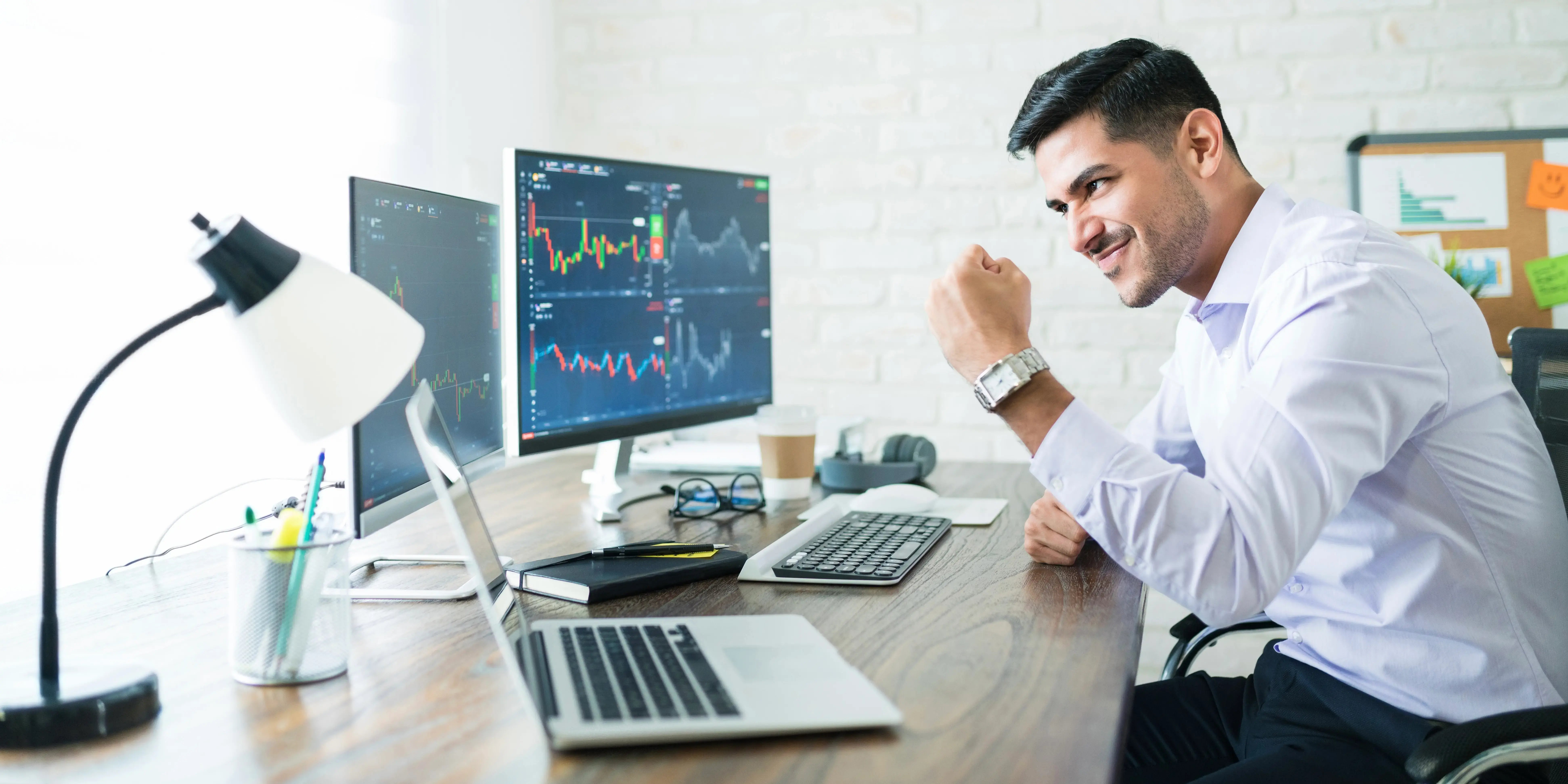 Hombre en computadora con gráficas. Invertir ahorros