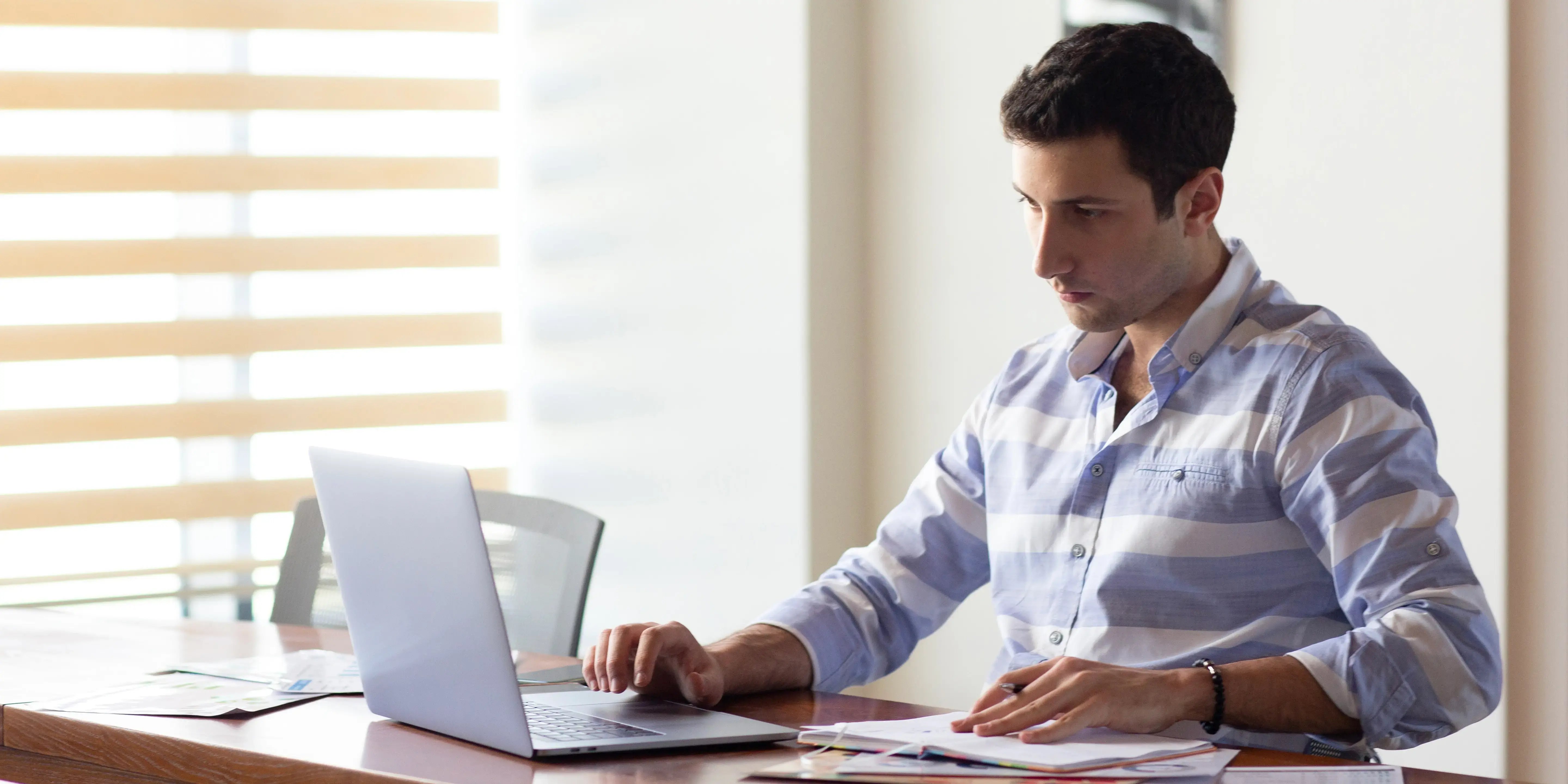 Hombre en escritorio con computadora. Oficina en casa