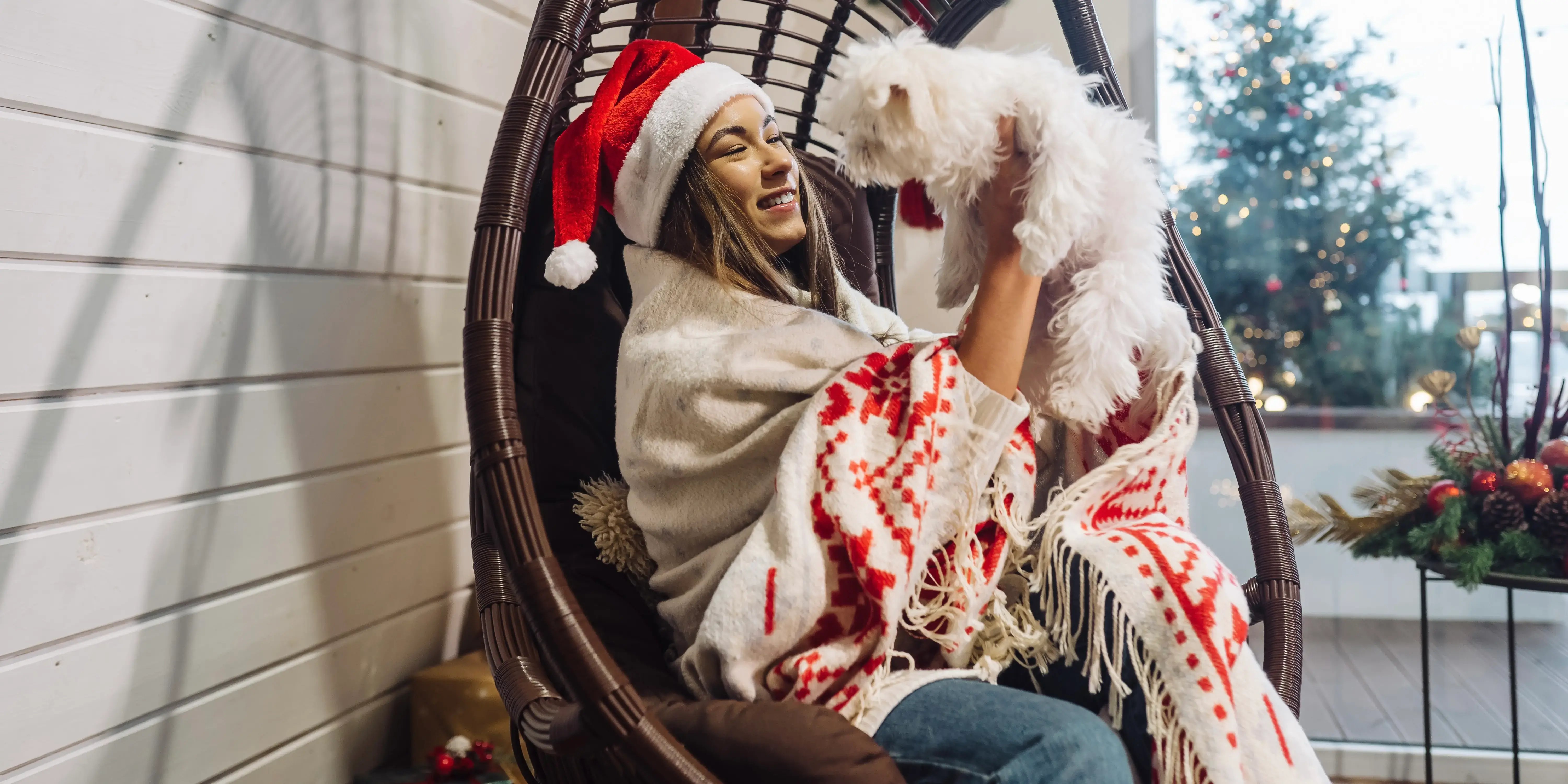 Mujer cargando a su perro. Terraza en Navidad