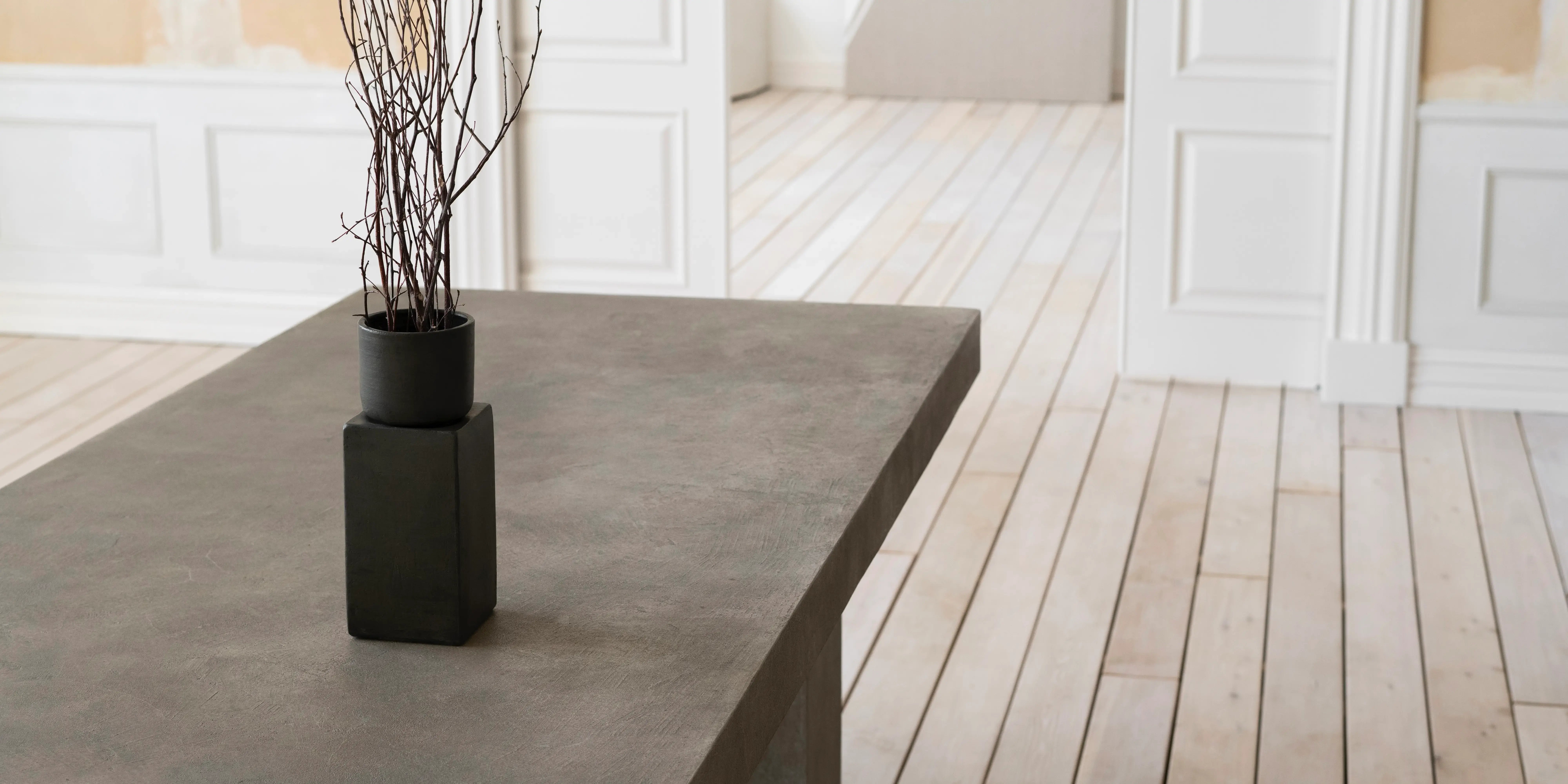 Mesa de piedra con piso de madera. Biofílica