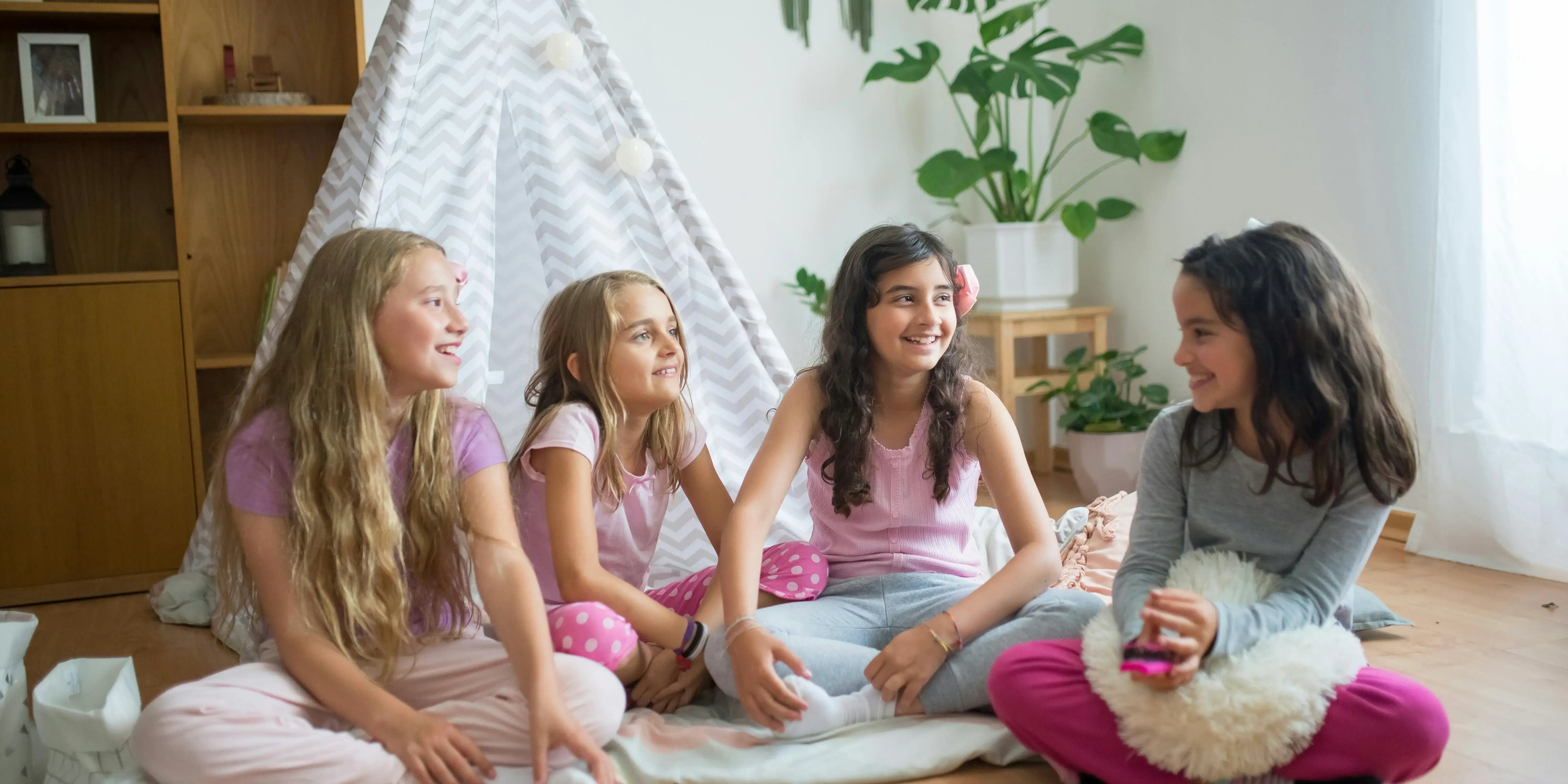 Niñas sentadas en el piso platicando. Vacaciones niños