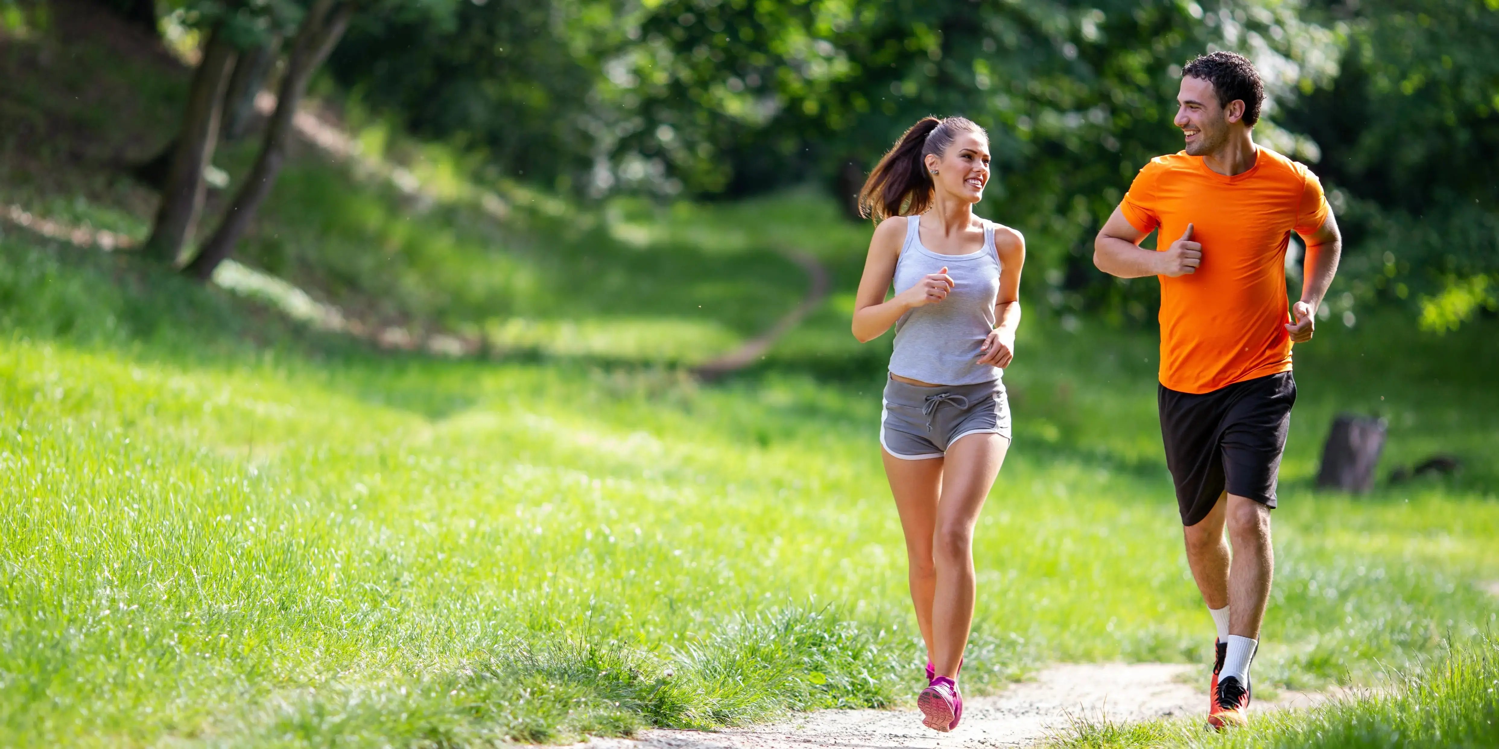 hombre y mujer corriendo en área verde. qué es sedentarismo