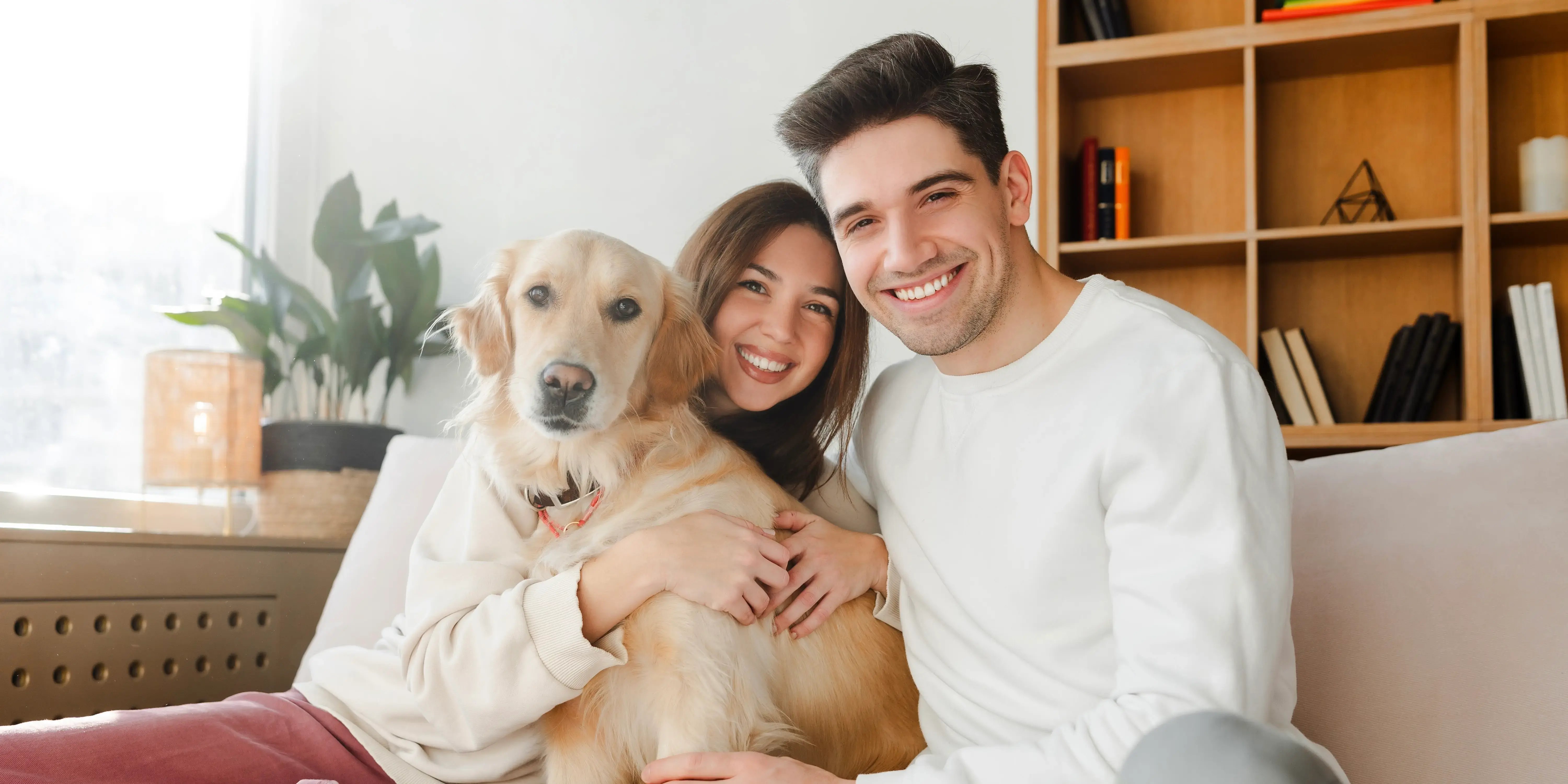 pareja abrazando a su perro. día mundial del pero