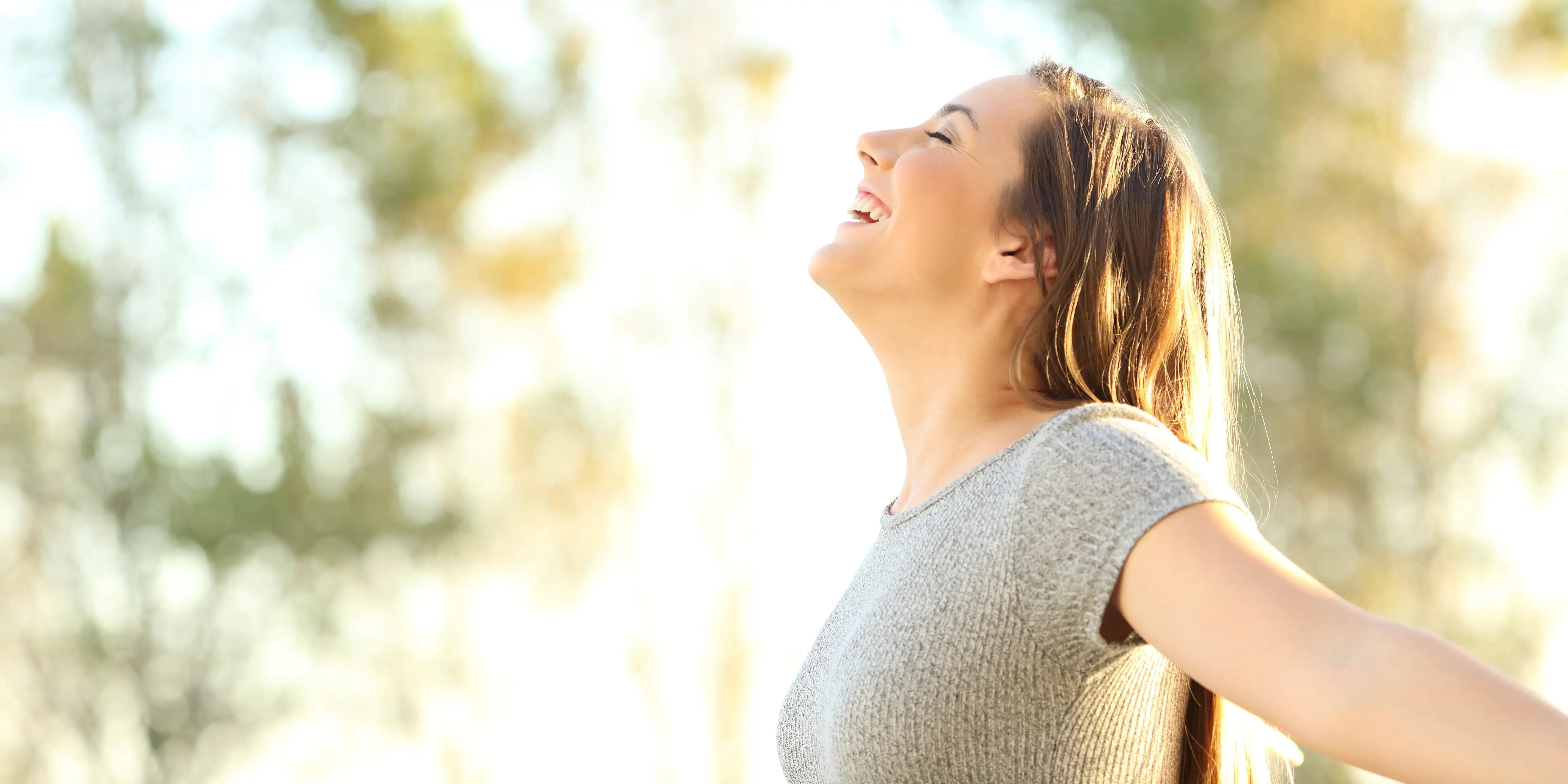 Qué es el bienestar y cómo conseguirlo. Mujer recibe los rayos del sol.