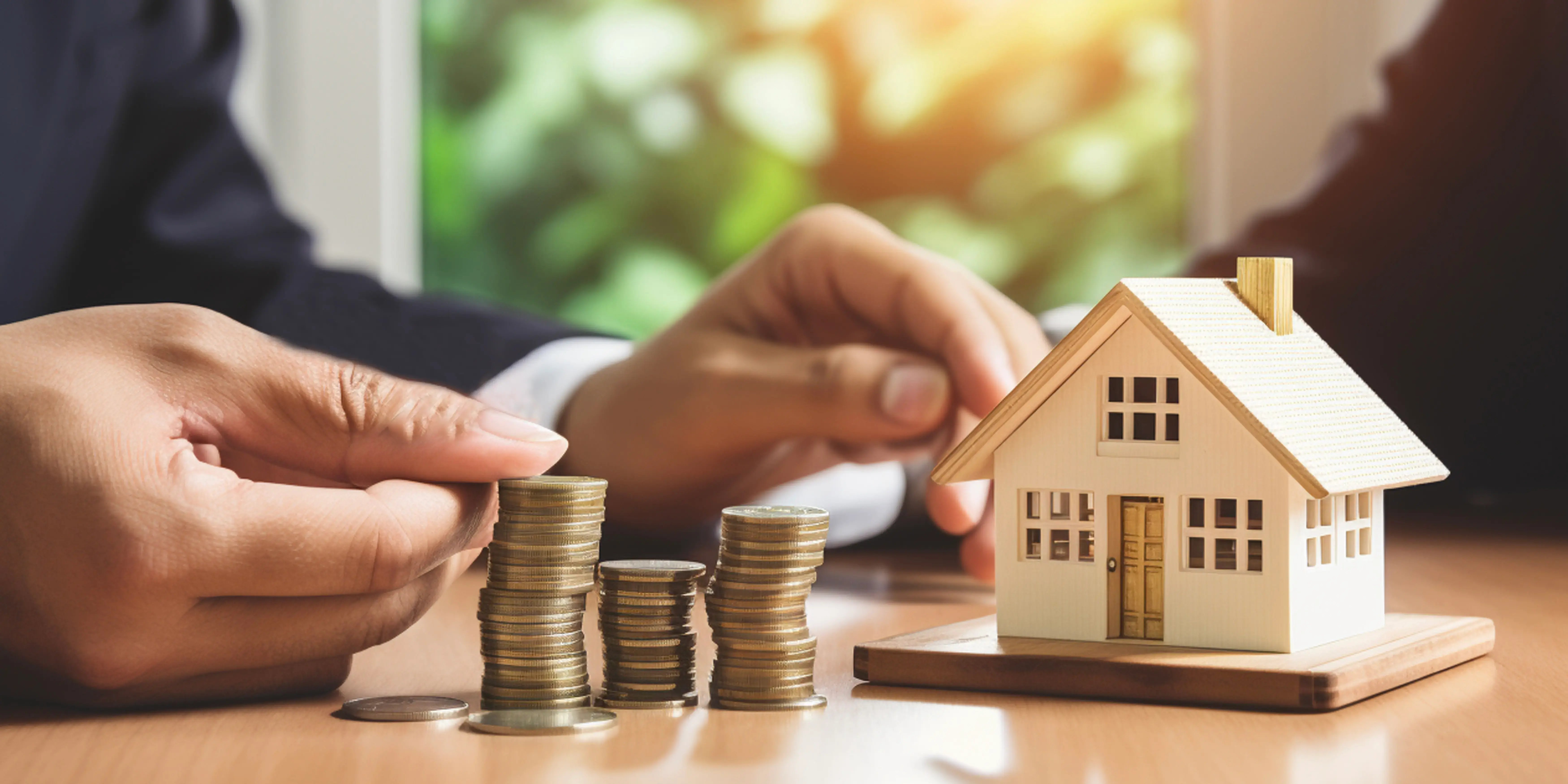 Hombre con unas monedas y una casa. Metas financieras