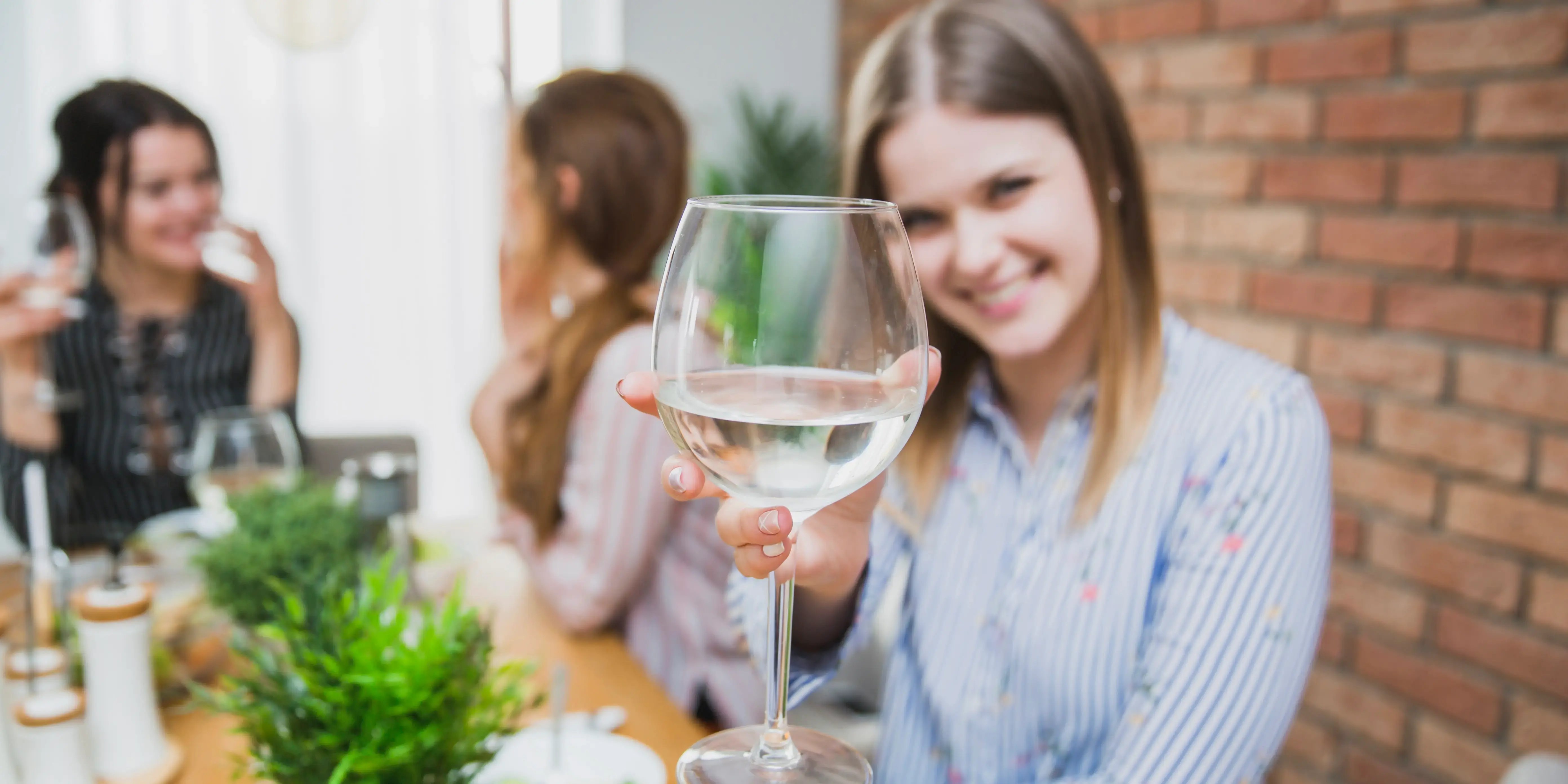 Mujer sosteniendo una copa de vino para brindar.